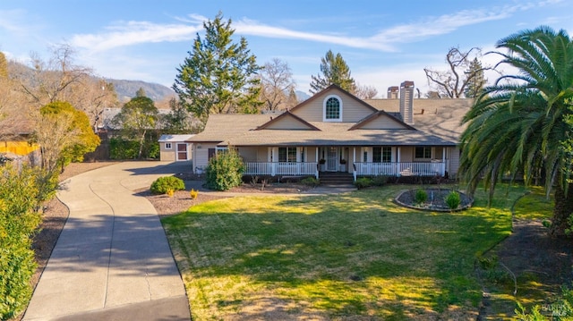 view of front of property featuring a mountain view, a front yard, and a porch