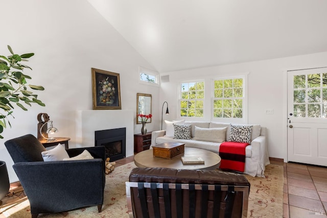 living room featuring light tile patterned floors and high vaulted ceiling