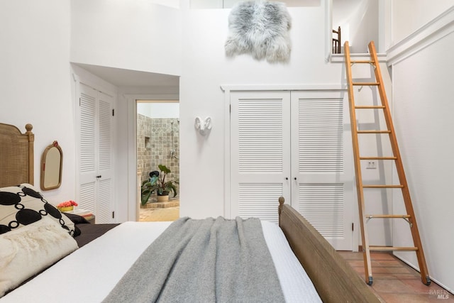 bedroom with a towering ceiling and two closets