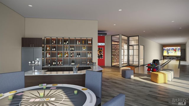 interior space with hardwood / wood-style flooring, dark brown cabinetry, and built in fridge