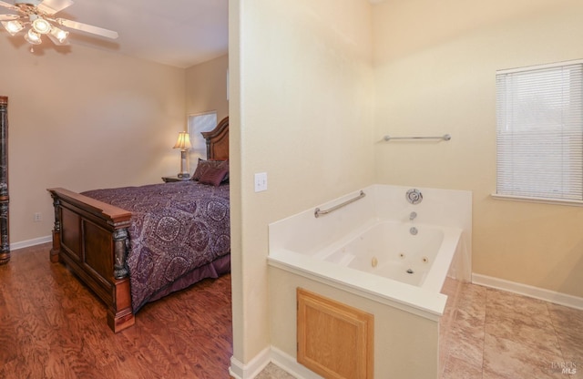 bathroom with a washtub, hardwood / wood-style floors, and ceiling fan