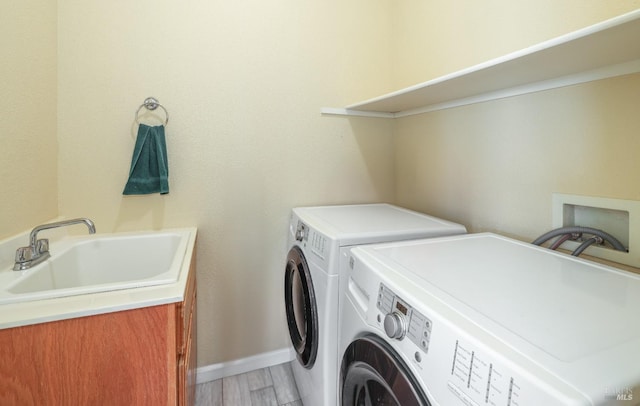 clothes washing area with sink, hardwood / wood-style flooring, and washing machine and dryer