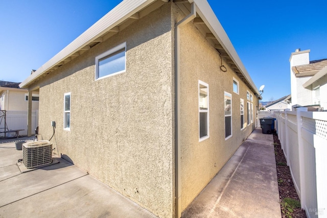 view of home's exterior with central AC unit and a patio