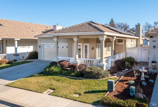 view of front of house featuring a garage, covered porch, and a front yard