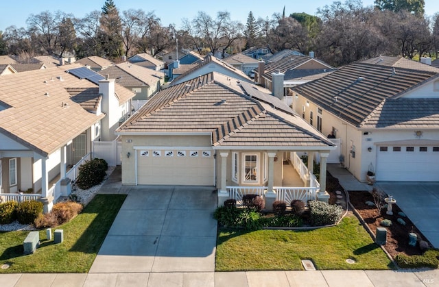 view of front of property featuring a garage, a front lawn, and a porch