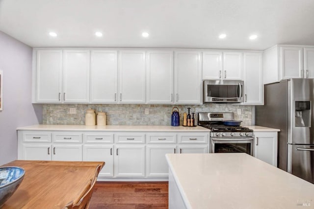 kitchen featuring backsplash, stainless steel appliances, and white cabinets