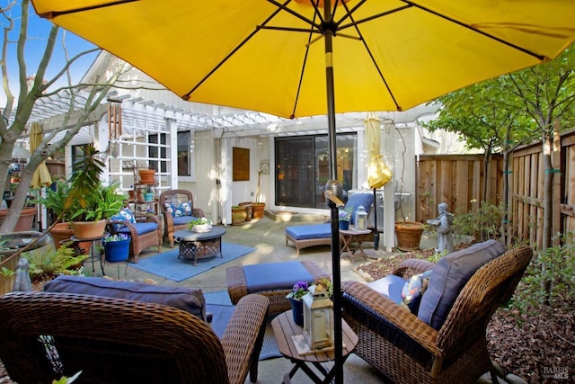 view of patio with area for grilling, a pergola, and an outdoor living space with a fire pit