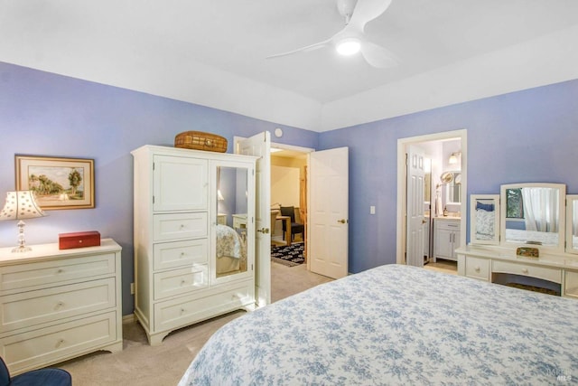 bedroom with light carpet, ensuite bath, and ceiling fan