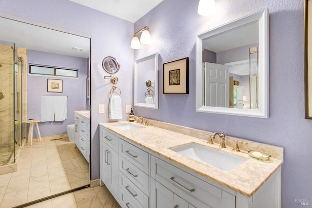 bathroom featuring vanity, a shower with shower door, and toilet