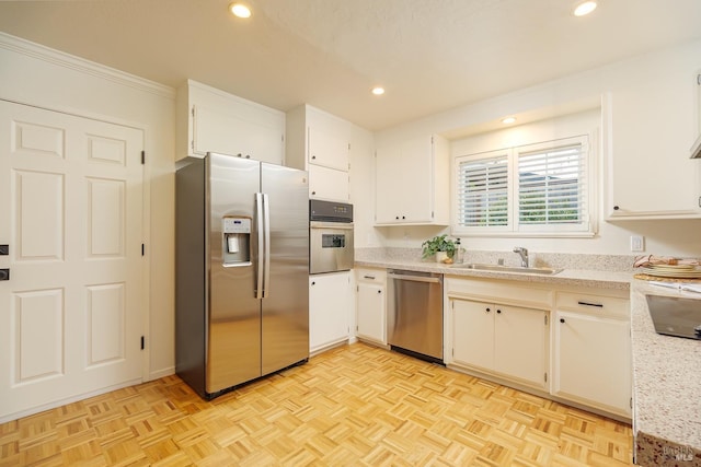 kitchen featuring stainless steel appliances, a sink, white cabinetry, and recessed lighting