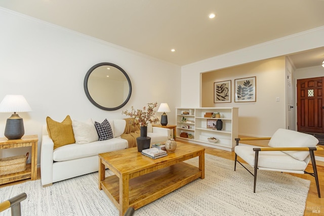 living room with light wood finished floors, ornamental molding, baseboards, and recessed lighting