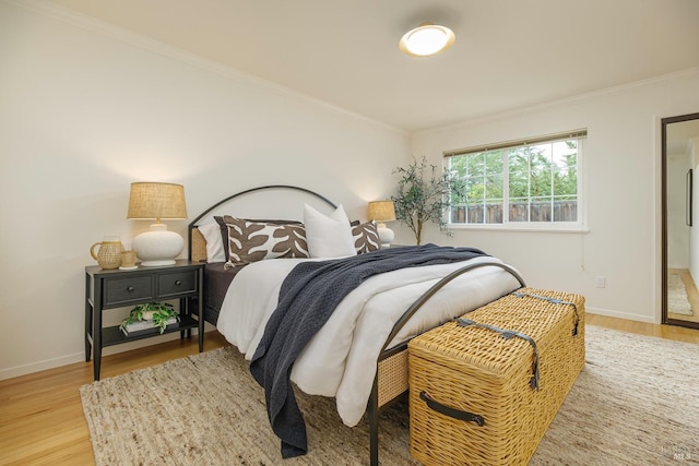 bedroom featuring crown molding, baseboards, and wood finished floors