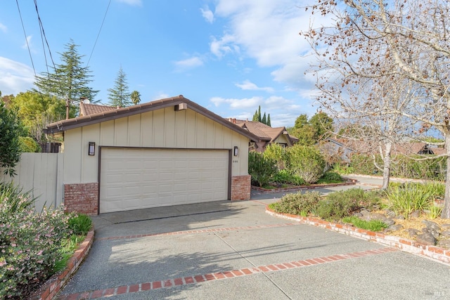 view of front facade with brick siding, driveway, a tiled roof, and fence