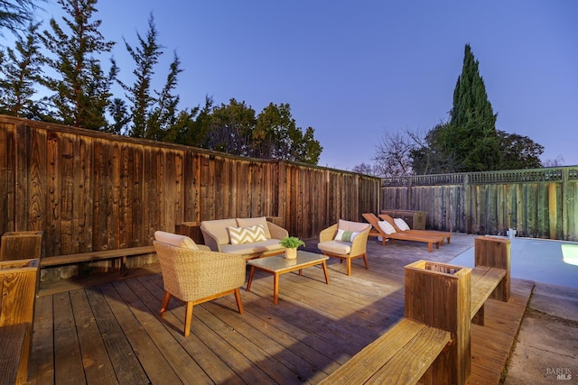 wooden terrace with outdoor lounge area and fence