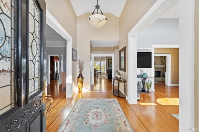 entryway featuring high vaulted ceiling and light wood-type flooring