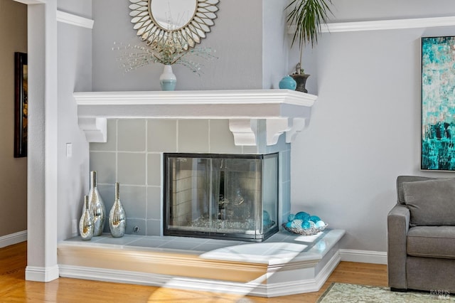 interior details with a tiled fireplace and hardwood / wood-style floors