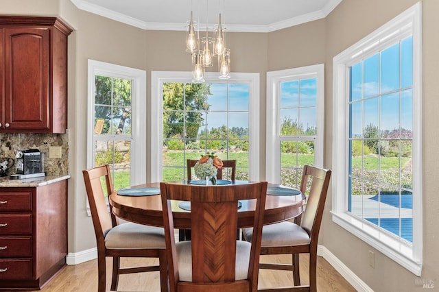 dining room with ornamental molding, a chandelier, and light hardwood / wood-style floors