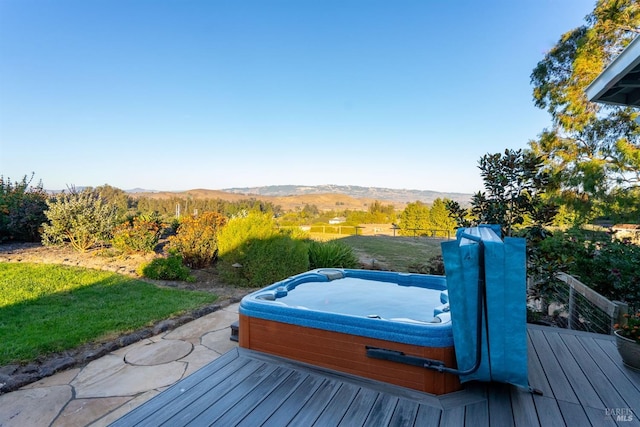 wooden deck featuring a mountain view and a lawn