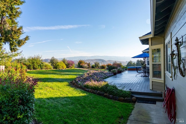 view of yard with a deck with mountain view