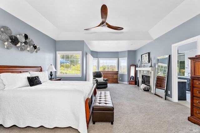 carpeted bedroom with ceiling fan and a tray ceiling