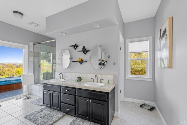 bathroom featuring vanity, a shower with shower door, and tile patterned floors