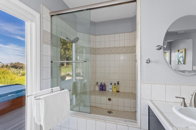 bathroom with a shower with door and vanity