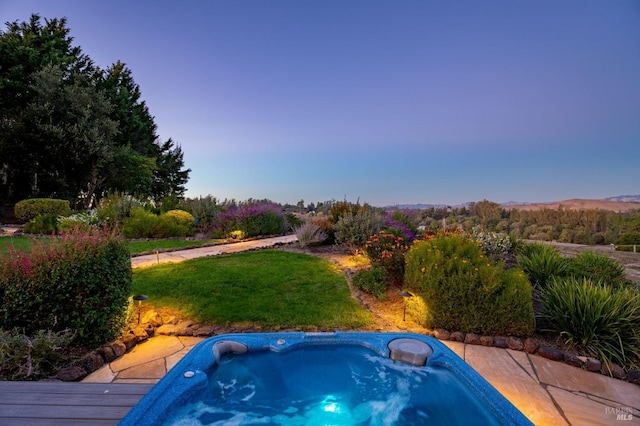 view of swimming pool featuring an outdoor hot tub and a lawn