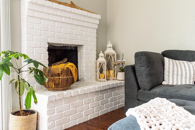 details featuring a brick fireplace and wood finished floors