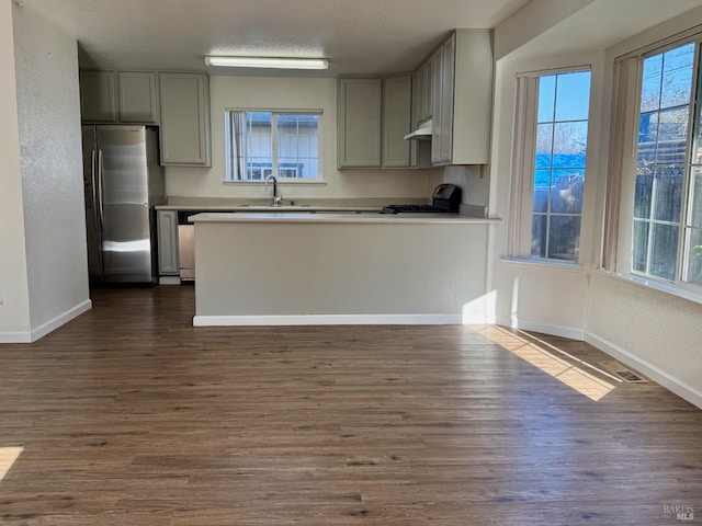 kitchen with stainless steel refrigerator with ice dispenser, sink, range, and dark hardwood / wood-style floors