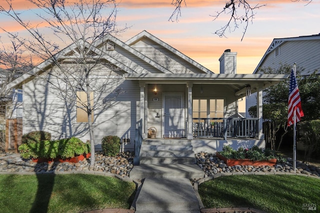 view of front of home with a yard and covered porch