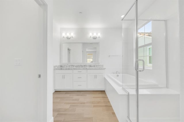 bathroom featuring plus walk in shower, a wealth of natural light, and vanity