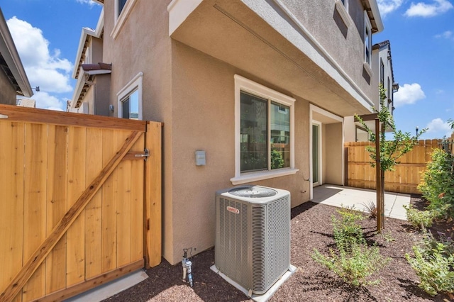 view of side of home with central AC and a patio area