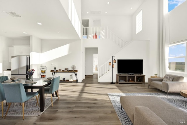 living room with hardwood / wood-style flooring and a high ceiling