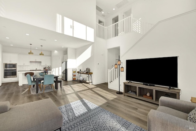 living room featuring hardwood / wood-style floors and a towering ceiling