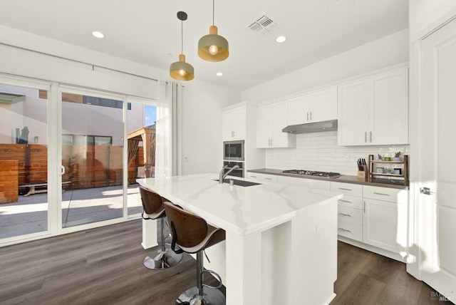 kitchen featuring pendant lighting, dark stone counters, and white cabinets