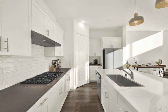 kitchen with decorative light fixtures, sink, white cabinets, decorative backsplash, and stainless steel appliances