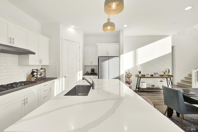 kitchen with white cabinetry, appliances with stainless steel finishes, sink, and pendant lighting