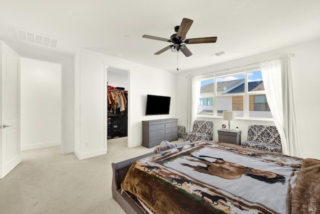 carpeted bedroom with ceiling fan, a spacious closet, and a closet