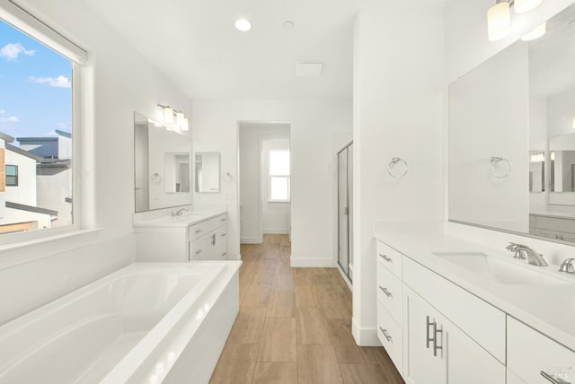 bathroom featuring independent shower and bath, vanity, and hardwood / wood-style flooring