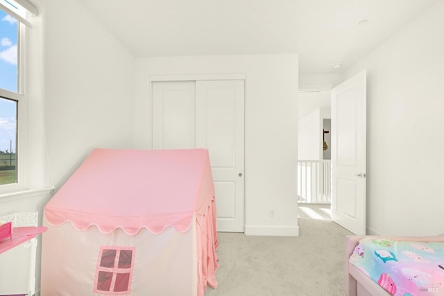 carpeted bedroom with a closet and multiple windows