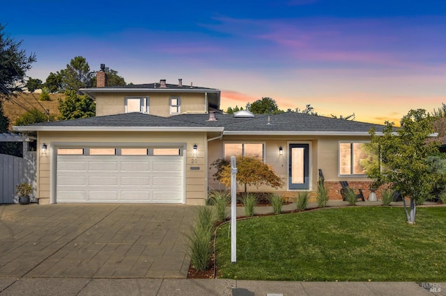 prairie-style house featuring a garage and a lawn