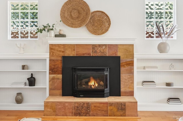 room details with a tiled fireplace and wood-type flooring