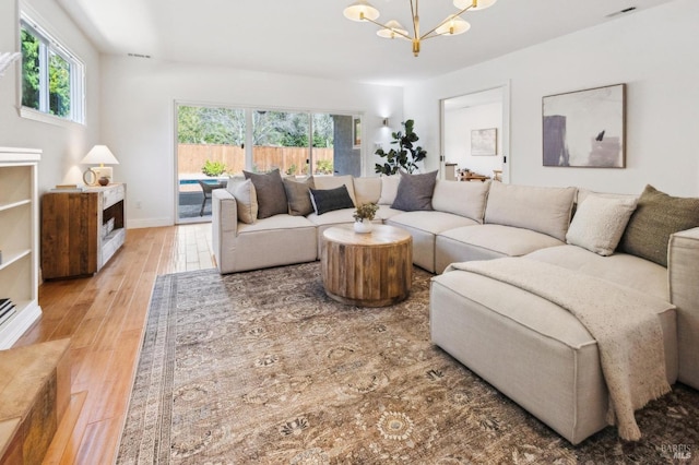 living room with plenty of natural light, a chandelier, and hardwood / wood-style floors