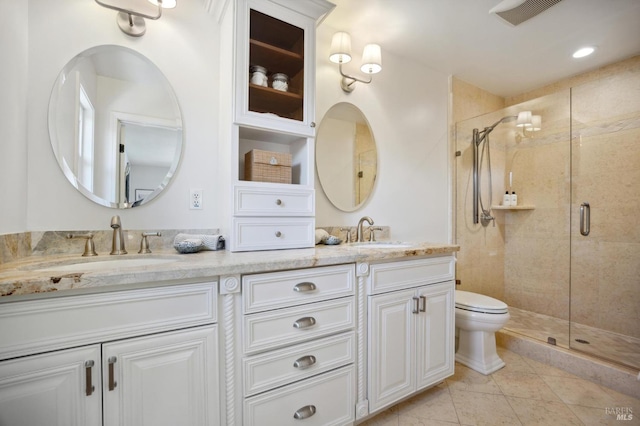 bathroom featuring tile patterned floors, vanity, toilet, and an enclosed shower