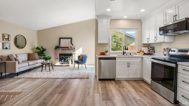 kitchen with white cabinetry, appliances with stainless steel finishes, sink, and light hardwood / wood-style flooring