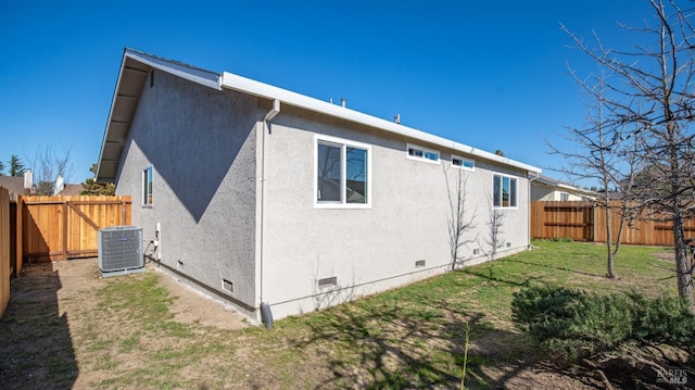 rear view of house featuring a yard and central AC unit