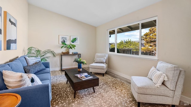 sitting room with hardwood / wood-style floors and vaulted ceiling