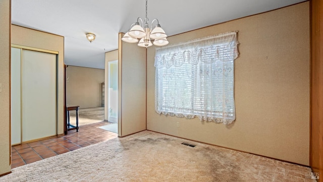 unfurnished dining area featuring an inviting chandelier and carpet floors