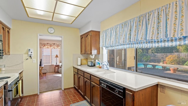 kitchen featuring black dishwasher, sink, decorative backsplash, and electric stove