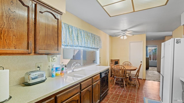 kitchen featuring sink, ceiling fan, black dishwasher, and white refrigerator